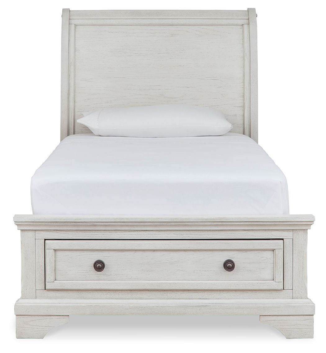 White sleigh bed with two storage drawers in the footboard and paneled headboard.