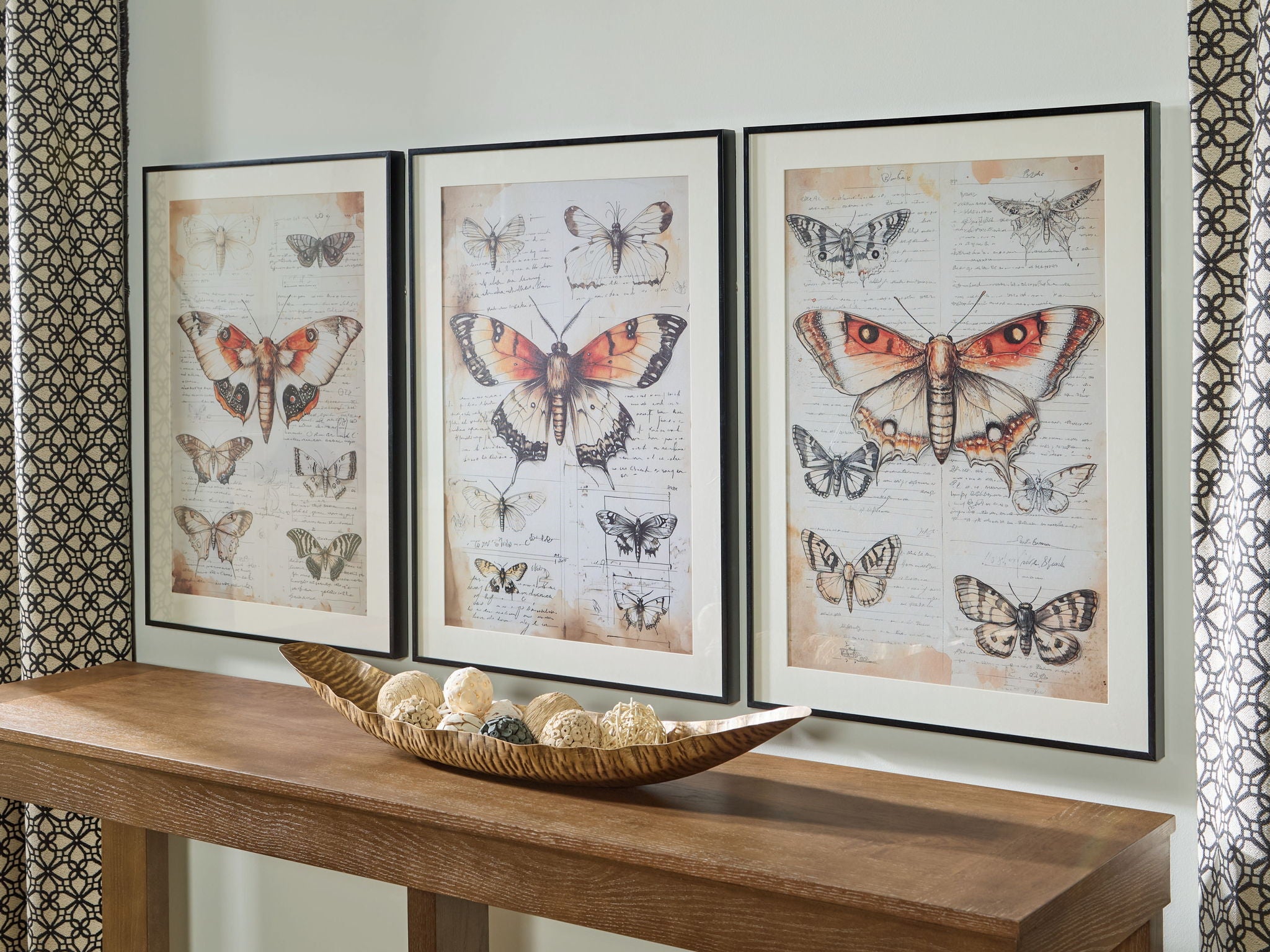 Three framed butterfly wall art prints on a console table display