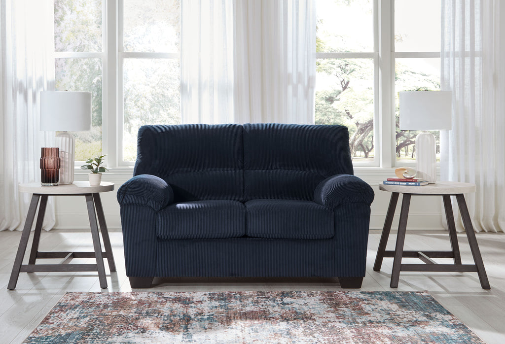 Navy corduroy loveseat with rolled arms, two-seat cushions, and dark wood feet