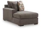 Dark brown chaise corner piece with padded chaise seat and patterned back throw pillow