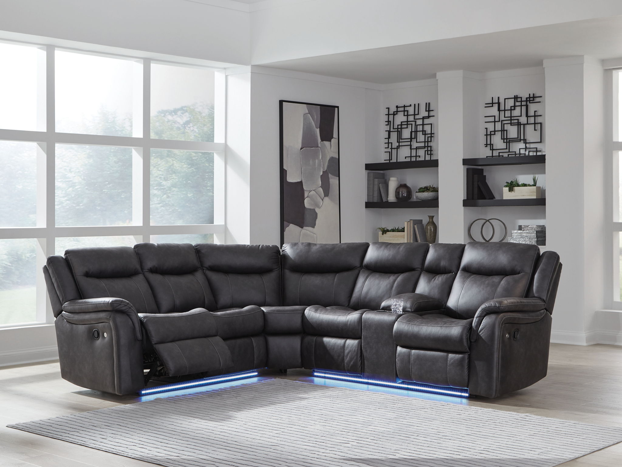 Dark carbon reclining sectional sofa with tufted back cushions and an extended chaise section.