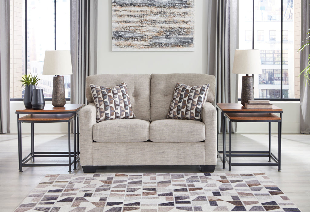 Light beige loveseat with two matching patterned cushions on the seats