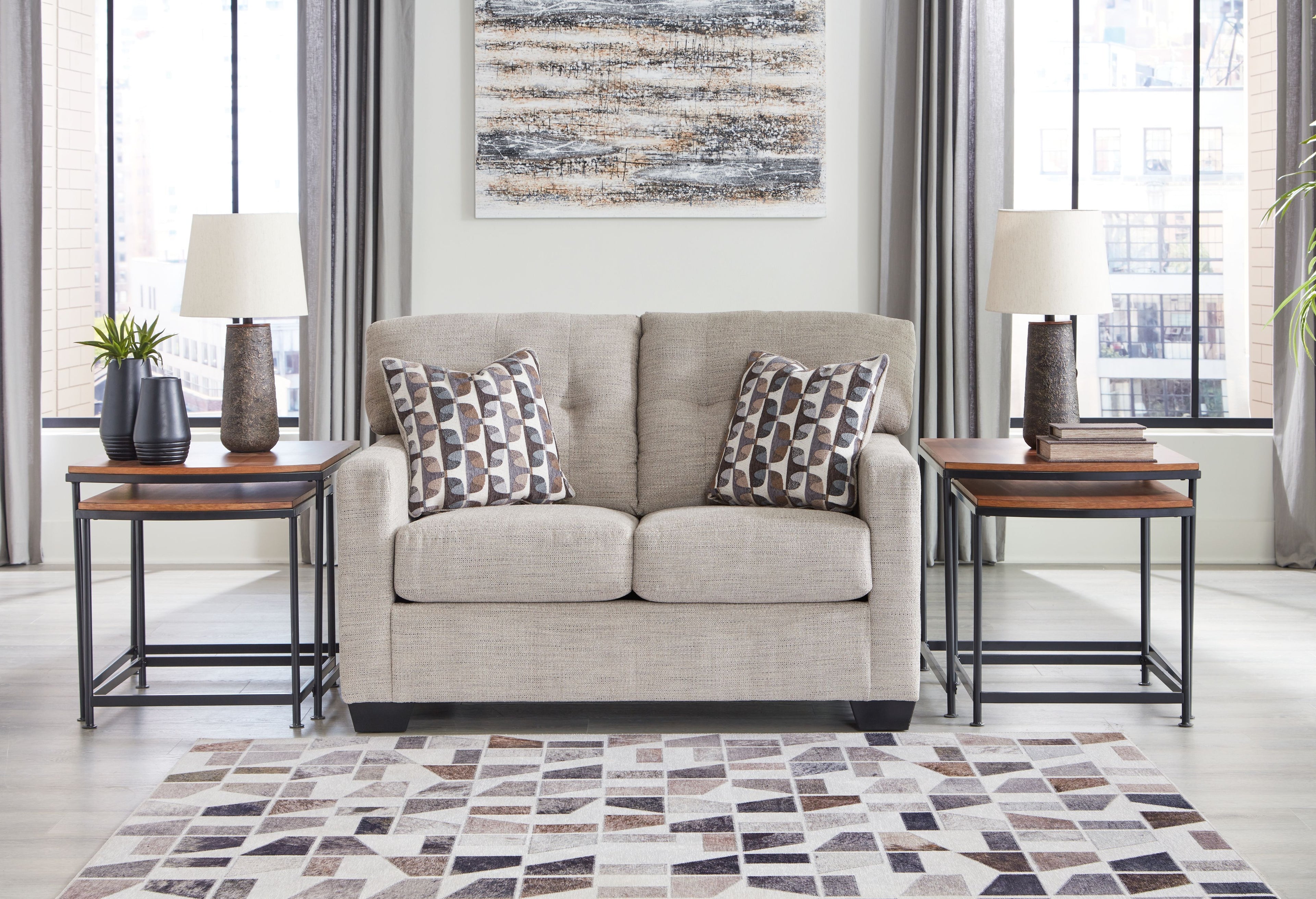 Light beige loveseat with two matching patterned cushions on the seats
