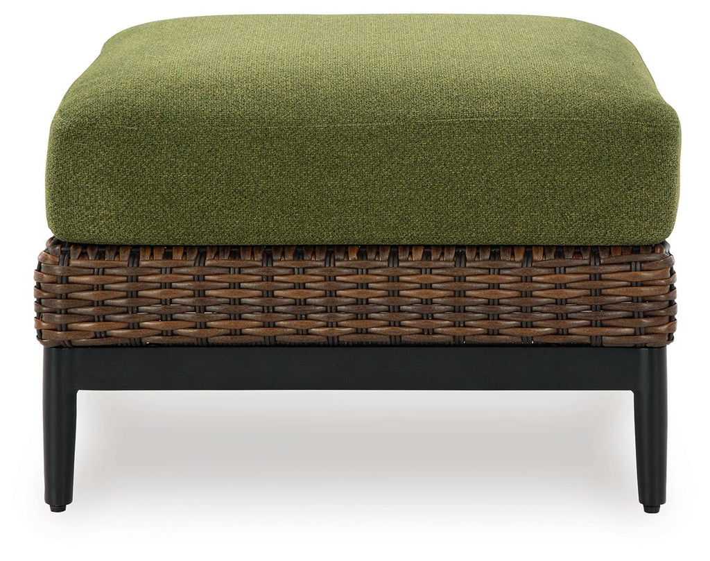 Brown wicker ottoman with green cushion, flat front view