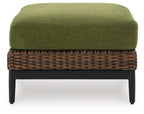Brown wicker ottoman with green cushion, flat front view