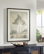 Dark wood-framed landscape wall art with three trees and foggy field