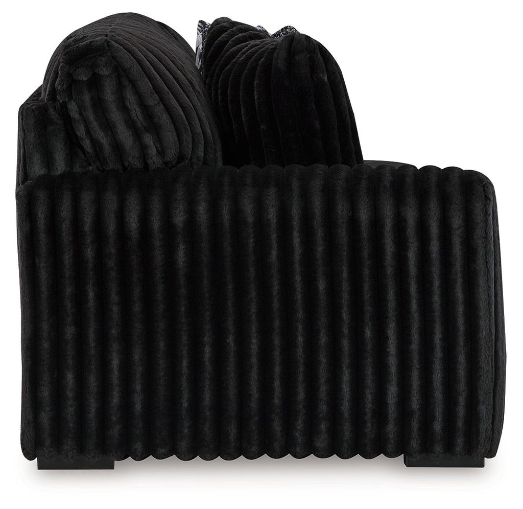Ribbed dark sectional sofa back and seat with deep channel stitching and rounded arms