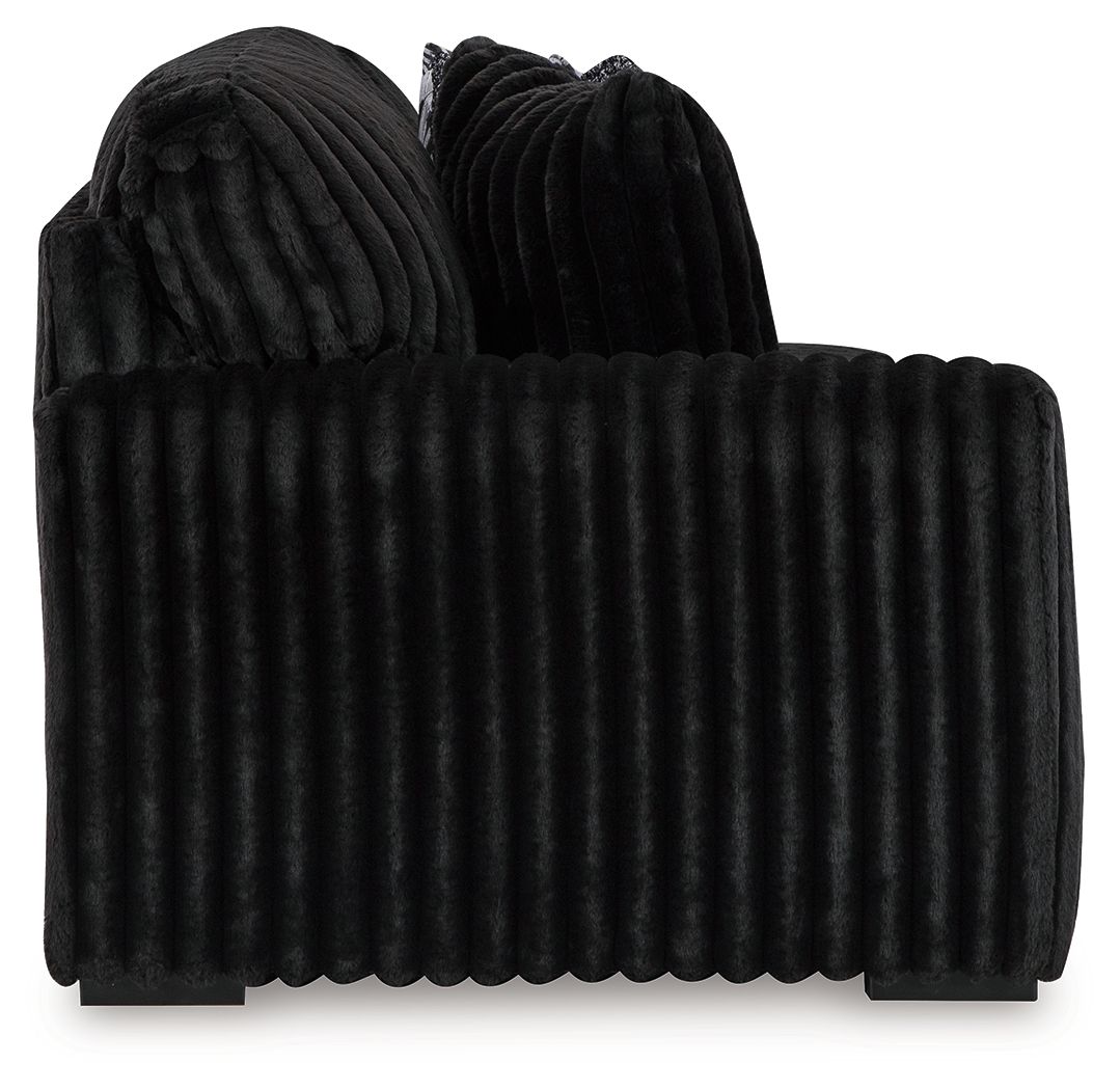 Ribbed dark sectional sofa back and seat with deep channel stitching and rounded arms