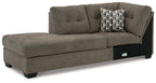 Brown corner chaise with tufted back and patterned throw pillow