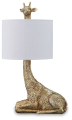Gold table lamp with sculpted giraffe base and white fabric drum shade.