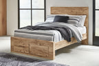 Storage bed with two drawers, light beige wood, black and gray striped bedding and pillows