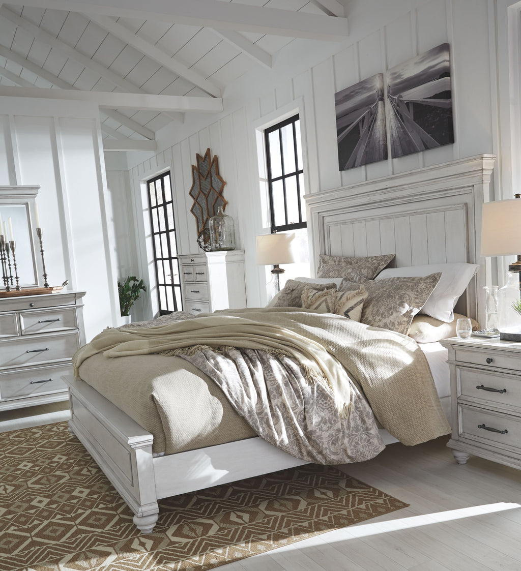 White panel bed with beige bedding and decorative pillows