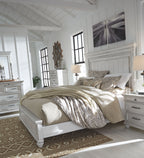White panel bed with beige bedding and decorative pillows