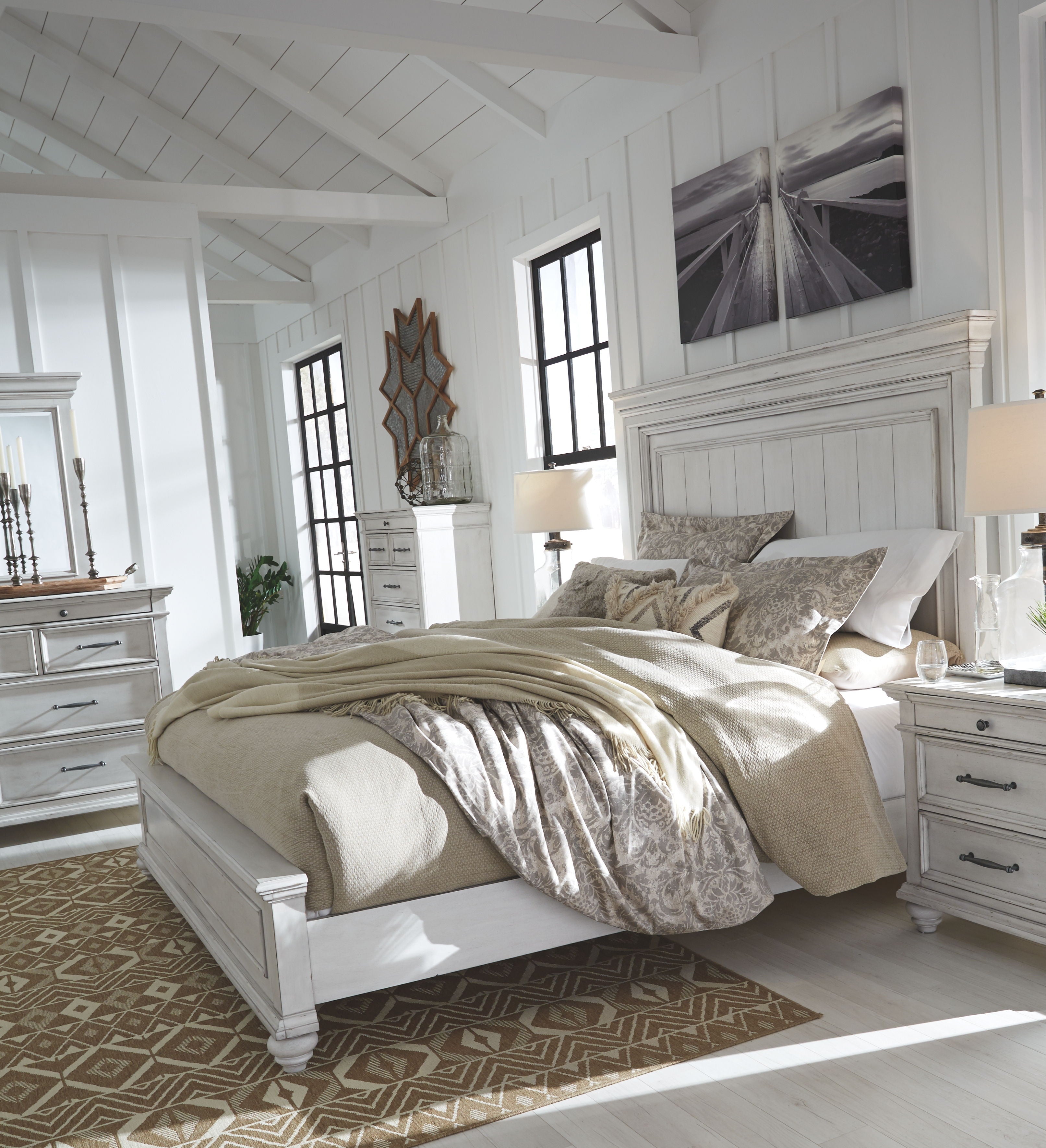 White panel bed with beige bedding and decorative pillows