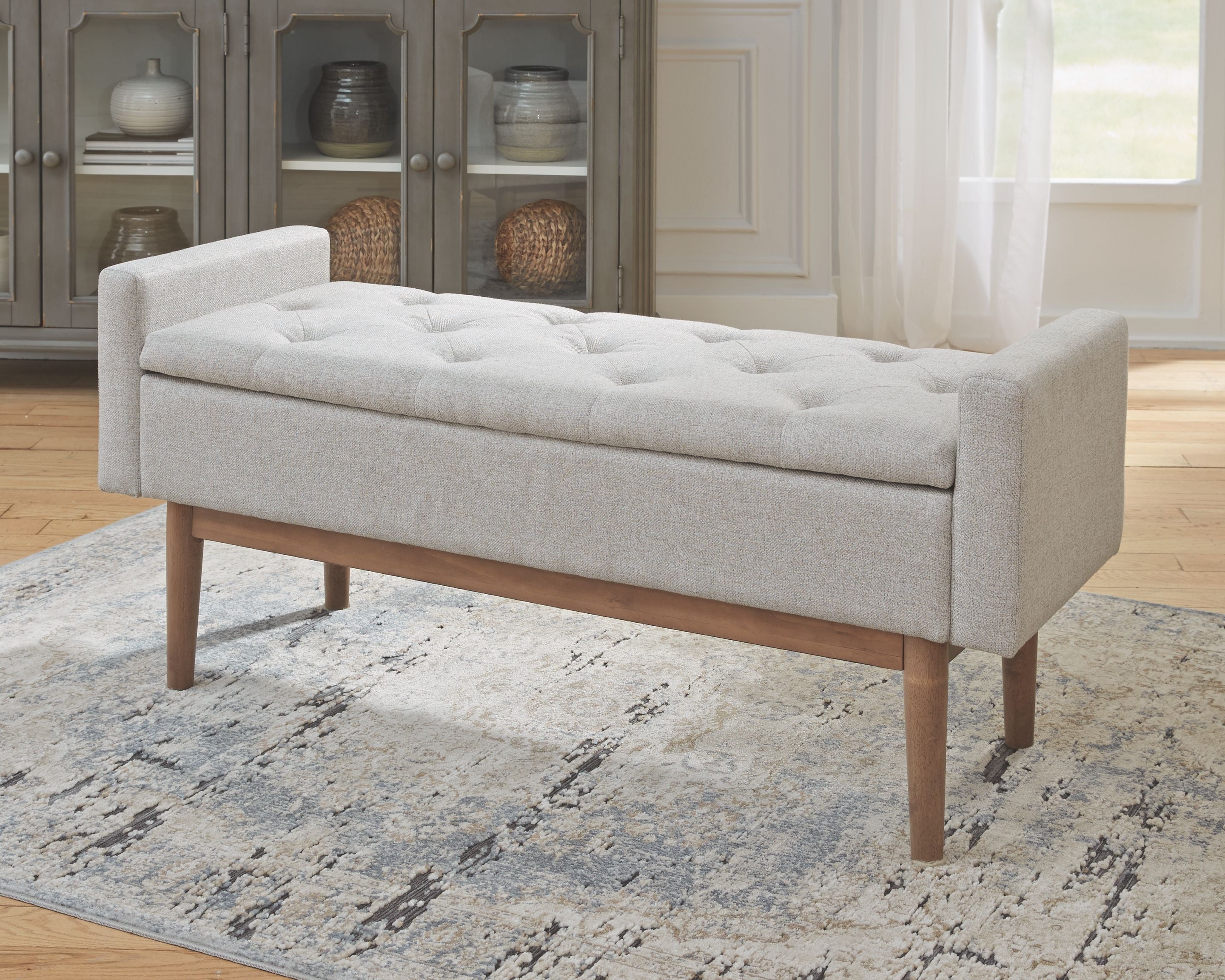 Upholstered storage bench with tufted seat in beige fabric, wooden legs