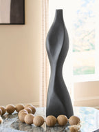 Black Judsen vase with twisted hourglass silhouette, open top and curved sides.