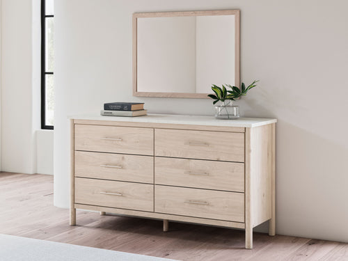 Rectangular tan bedroom mirror above a light wood dresser