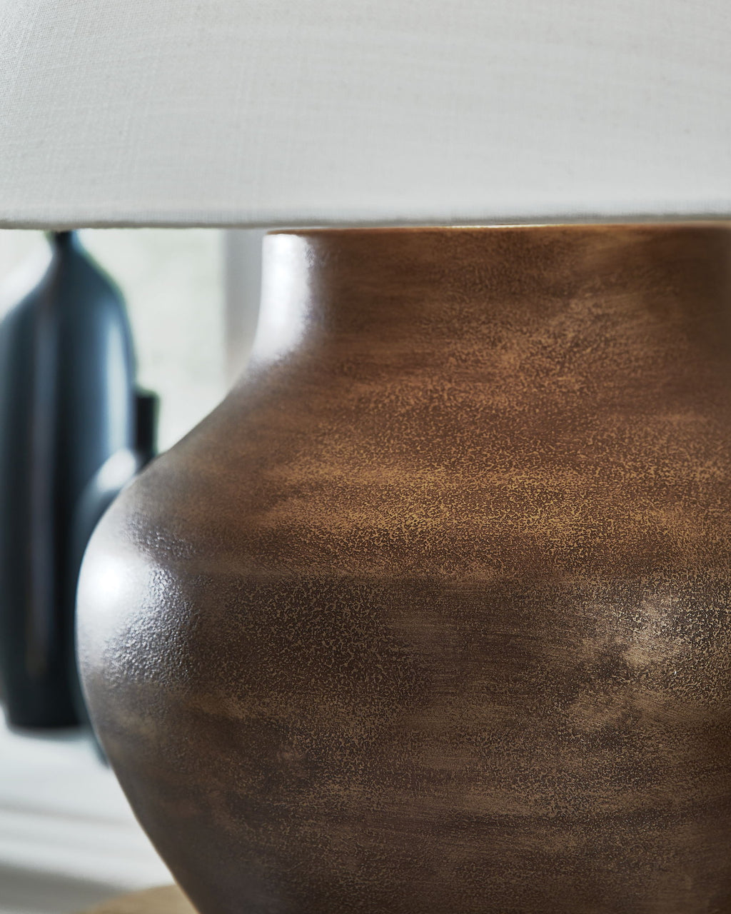 Antique copper lamp base with mottled metal texture, rounded shape, and neck