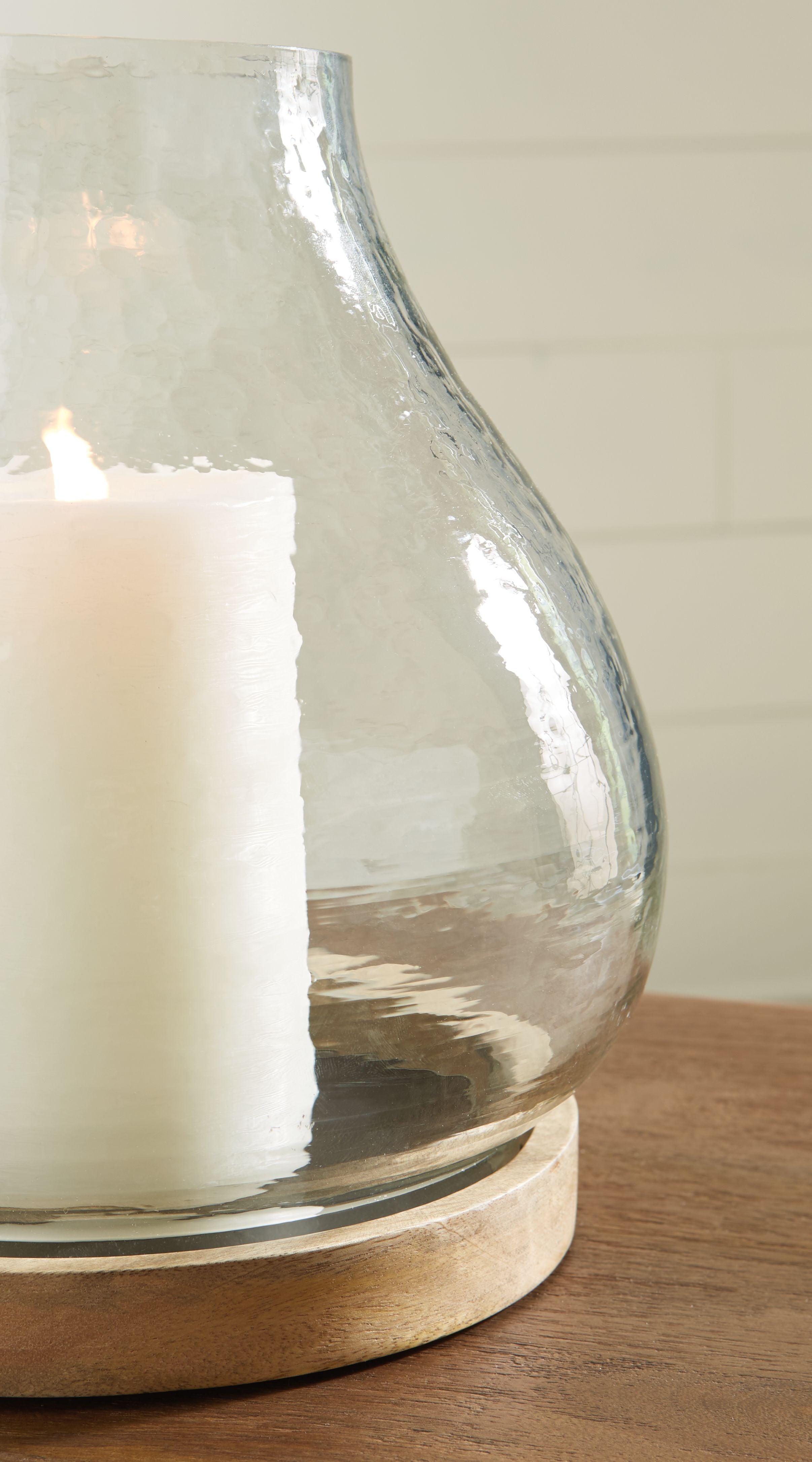 Clear glass vase candle holder with round wooden base and white candle
