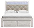 White panel bed with light gray upholstered headboard and two-drawer footboard storage.