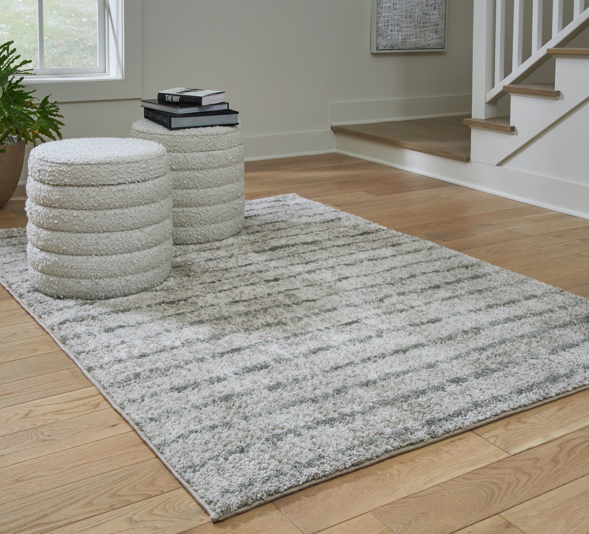 Cream and green area rug laid on wood floor, textured low shag-like pile
