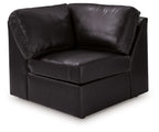 Black upholstered wedge armchair with padded armrests and boxy seat