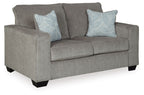 Light gray loveseat with two light blue patterned throw pillows and wide track arms