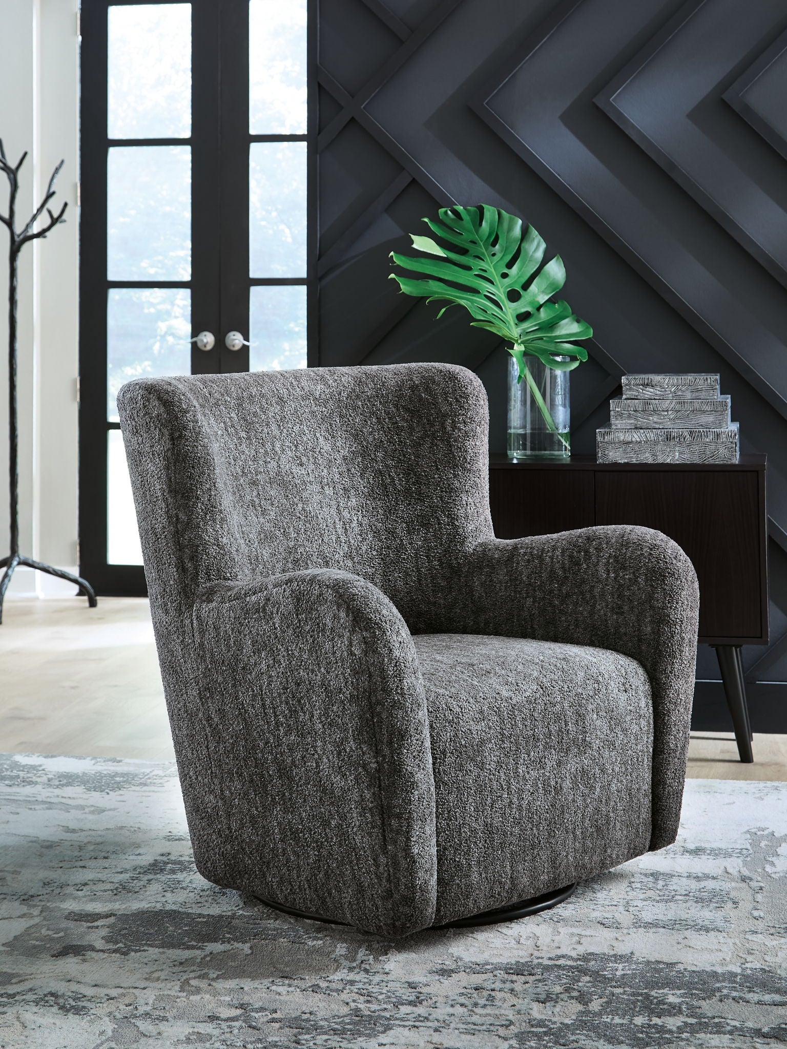 Dark gray swivel glider accent chair with padded arms, tall back, and black circular base