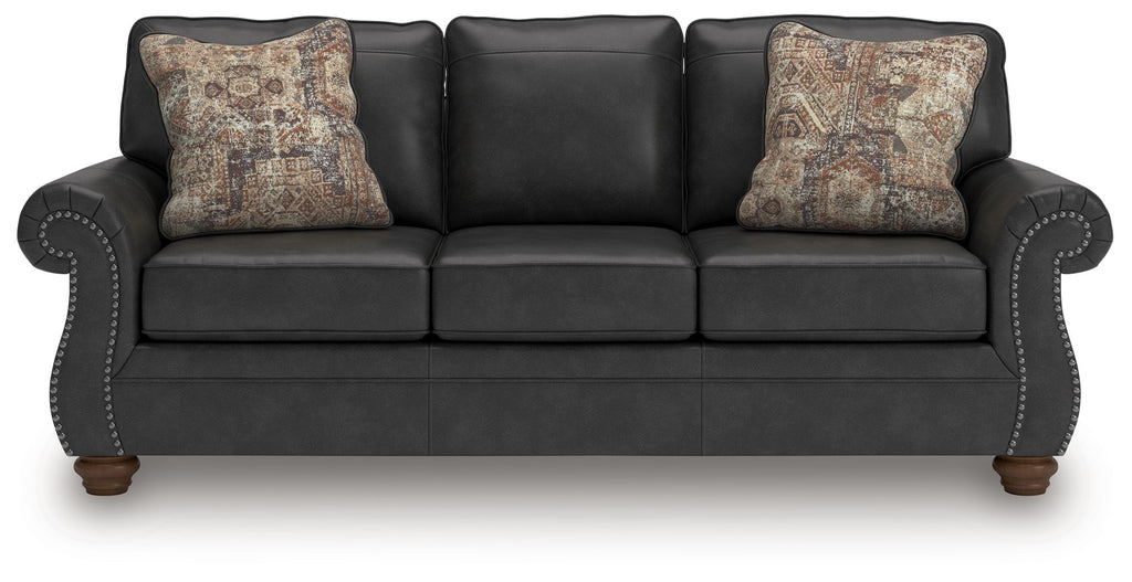 Chasemore sofa in dark gray with two patterned throw pillows and curved arms