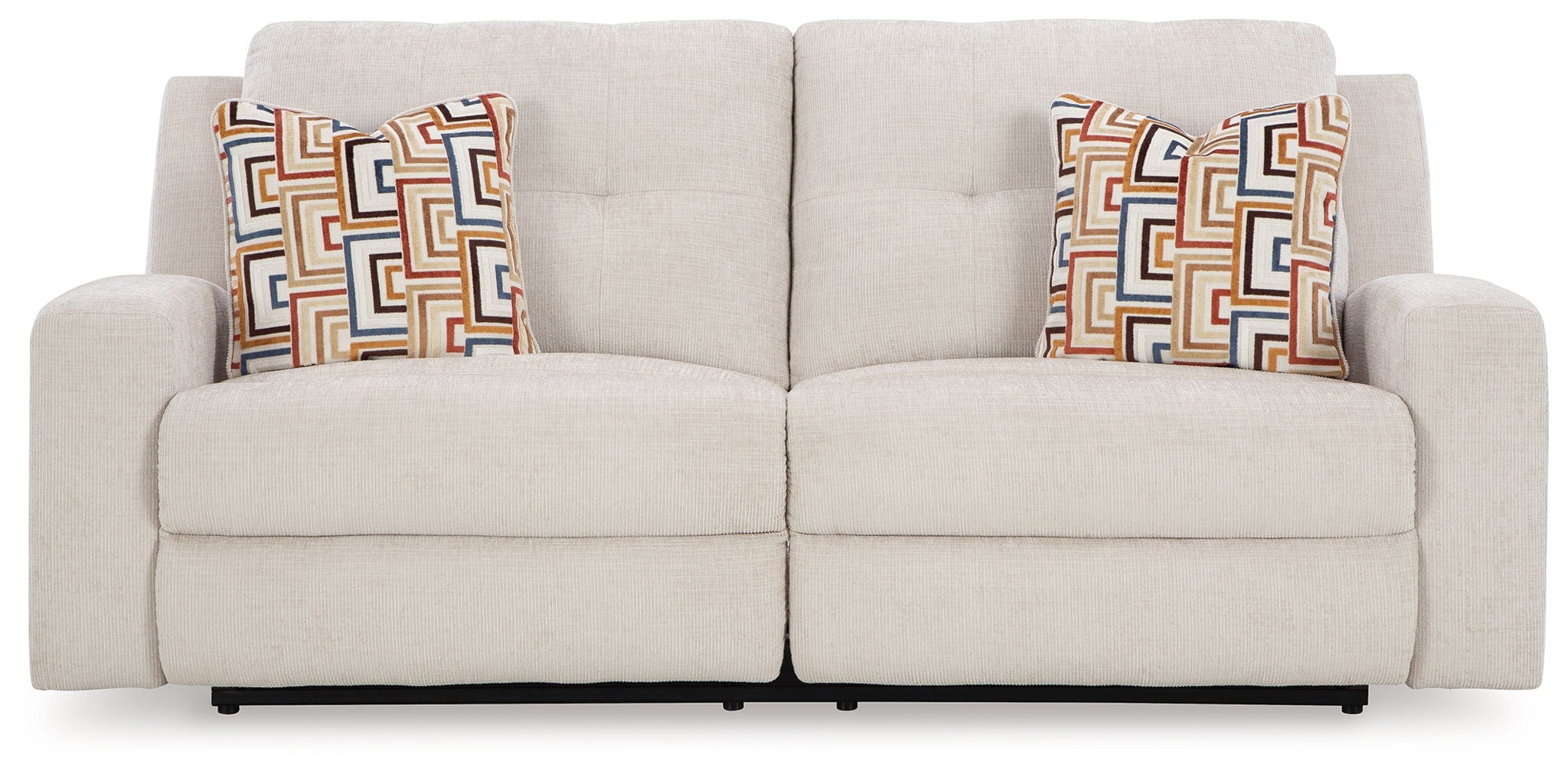 Beige reclining sofa with split back and patterned square throw pillows