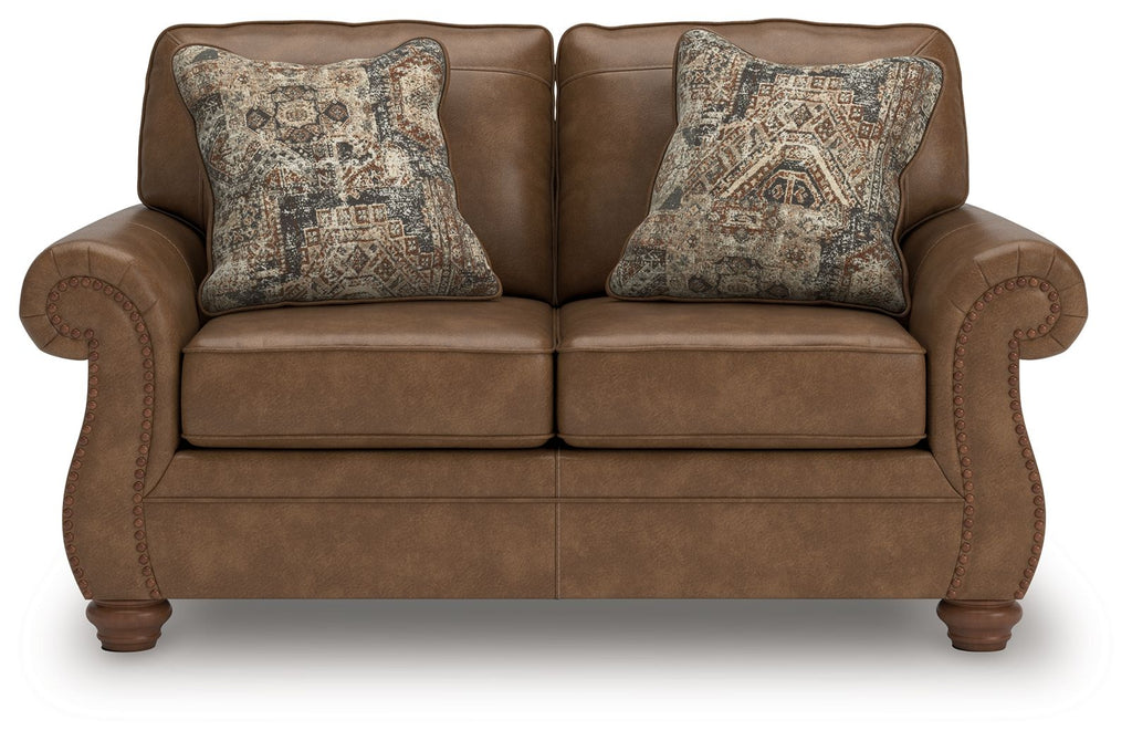 Dark brown loveseat with two square patterned throw pillows and cushioned arms