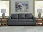 Dark gray leather sofa with three seat cushions and tufted back panels
