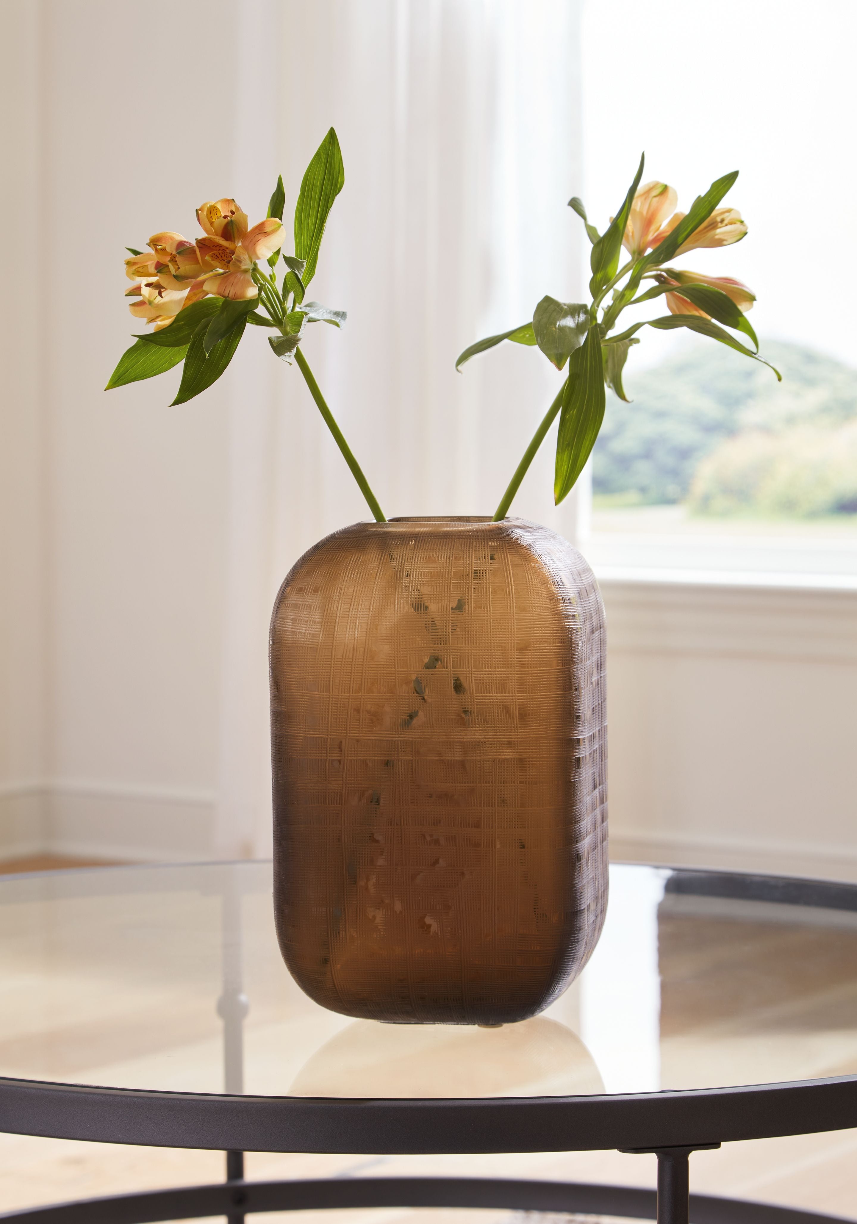 Dark brown vase with open top and vertical woven texture, holding stems