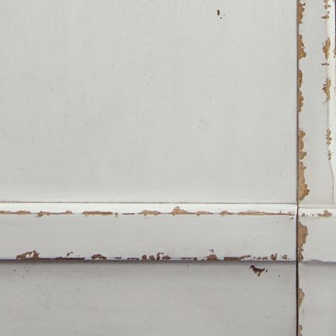 Chipped white finish detail on TV stand panel with distressed edges