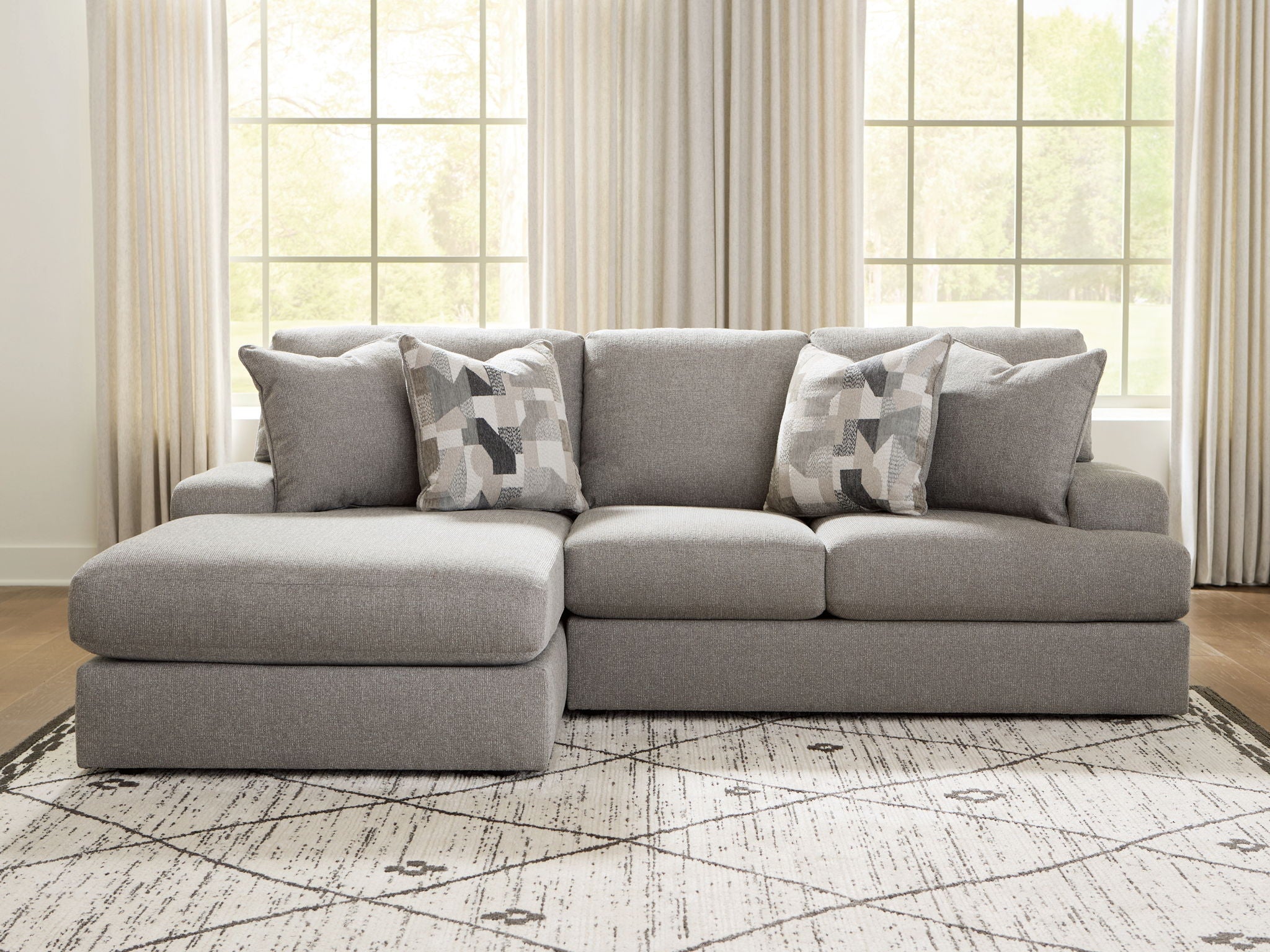 Lindon sectional sofa in smoke gray with three seat cushions and patterned accent pillows