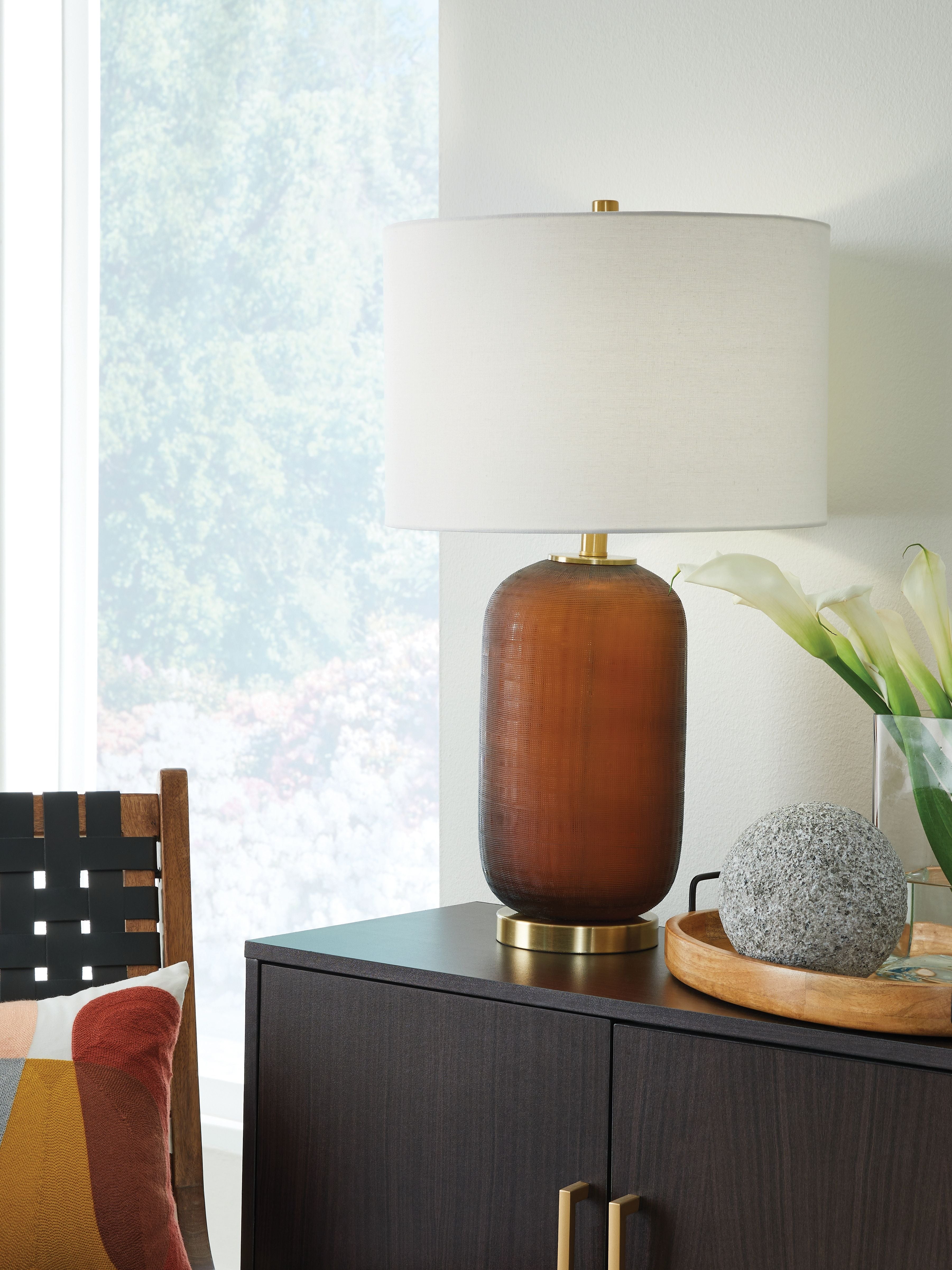 Amber glass table lamp with white drum shade and brass stem