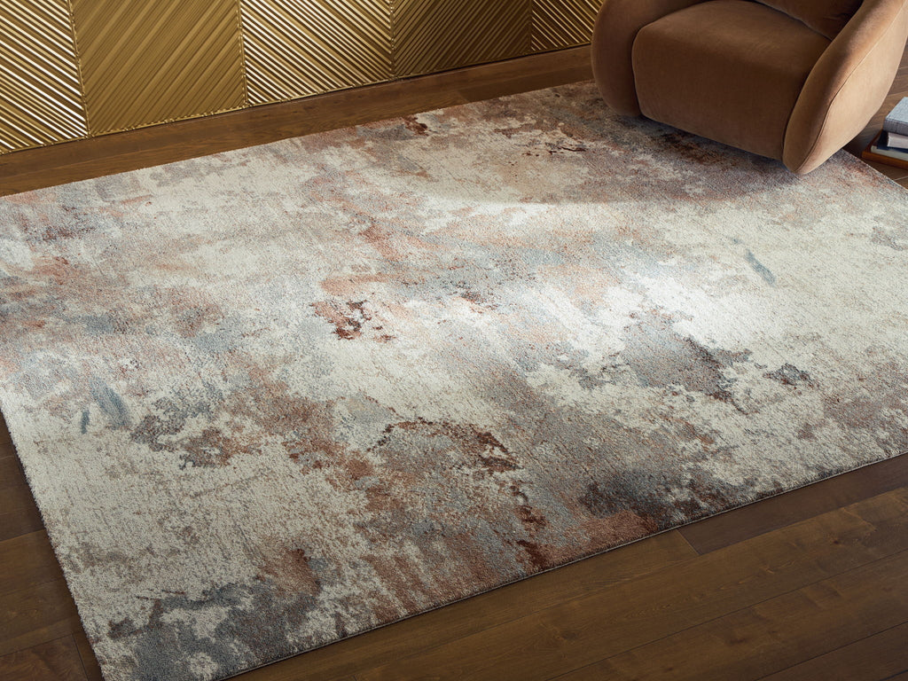 Distressed abstract area rug in beige and gray with rust spots