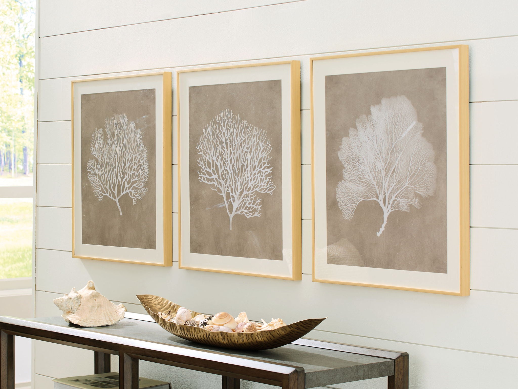 Three framed tree silhouette wall art prints in taupe and white, each in a light frame