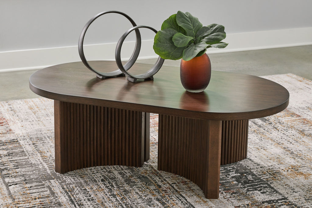 Oval dark brown cocktail table with ribbed base and flat oval tabletop