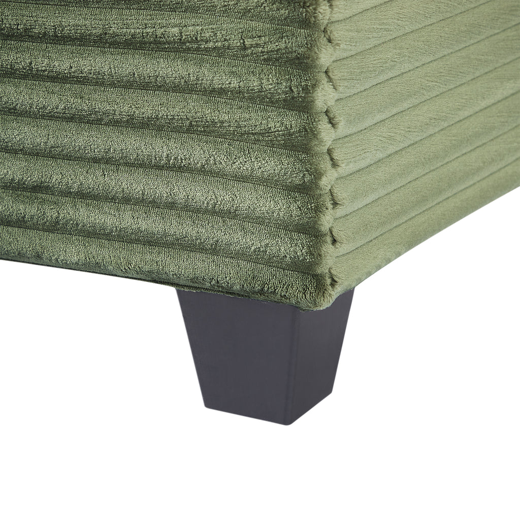 Green corduroy sofa armrest detail with dark base legs