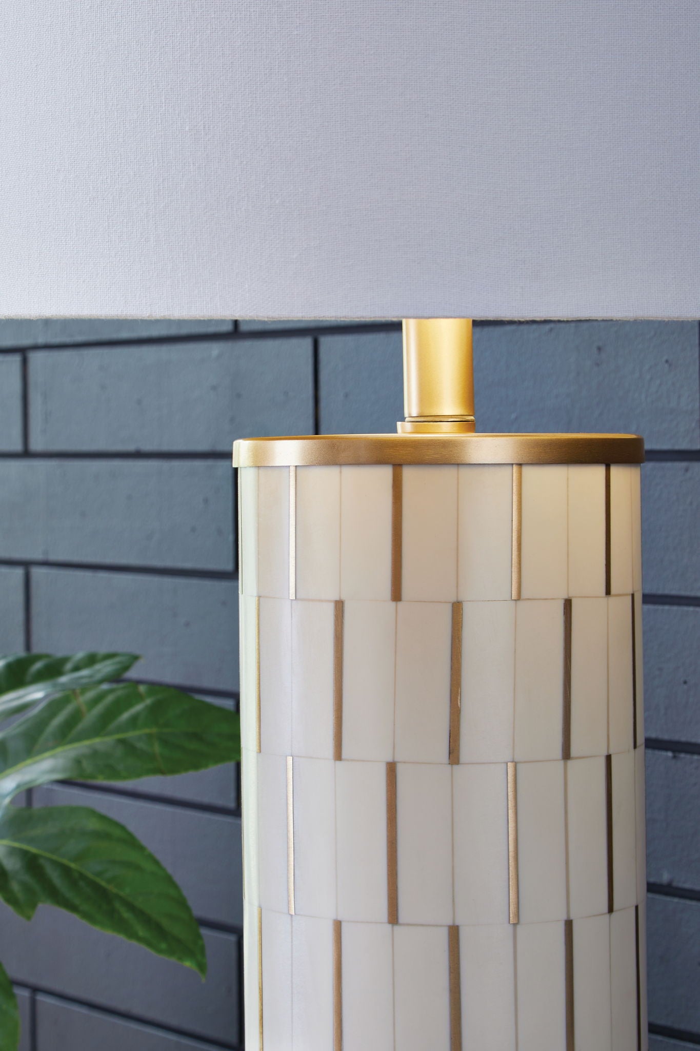 White poly table lamp with gold socket and fabric shade, ribbed cylindrical body