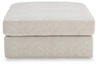 Beige upholstered ottoman with smooth rounded top and thick, padded sides