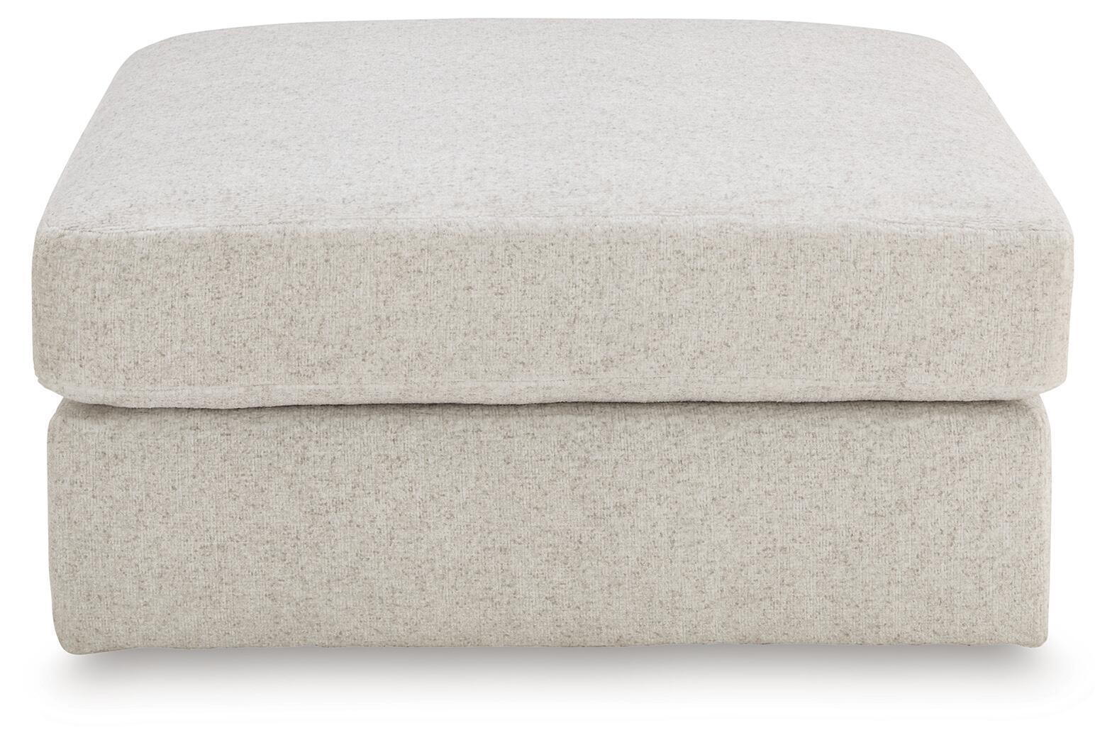 Beige upholstered ottoman with smooth rounded top and thick, padded sides