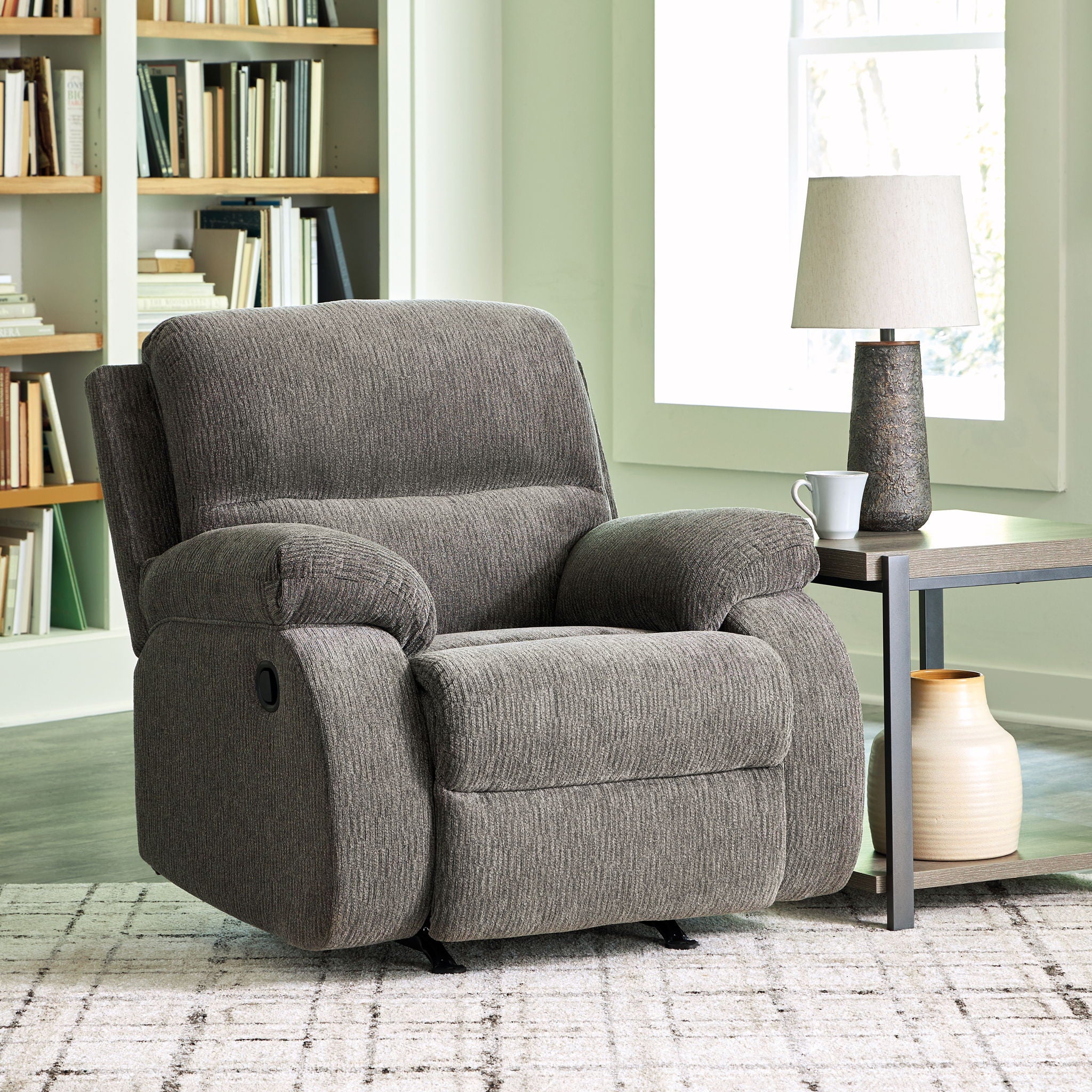 Dark gray rocker recliner chair with cushioned back and padded armrests