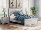 Light wood panel bed with upholstered headboard and a blue bedding set