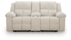 Double reclining loveseat with console, light beige upholstery, padded back and armrests