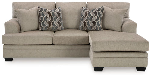 Taupe sofa chaise with three seat cushions and two geometric patterned throw pillows