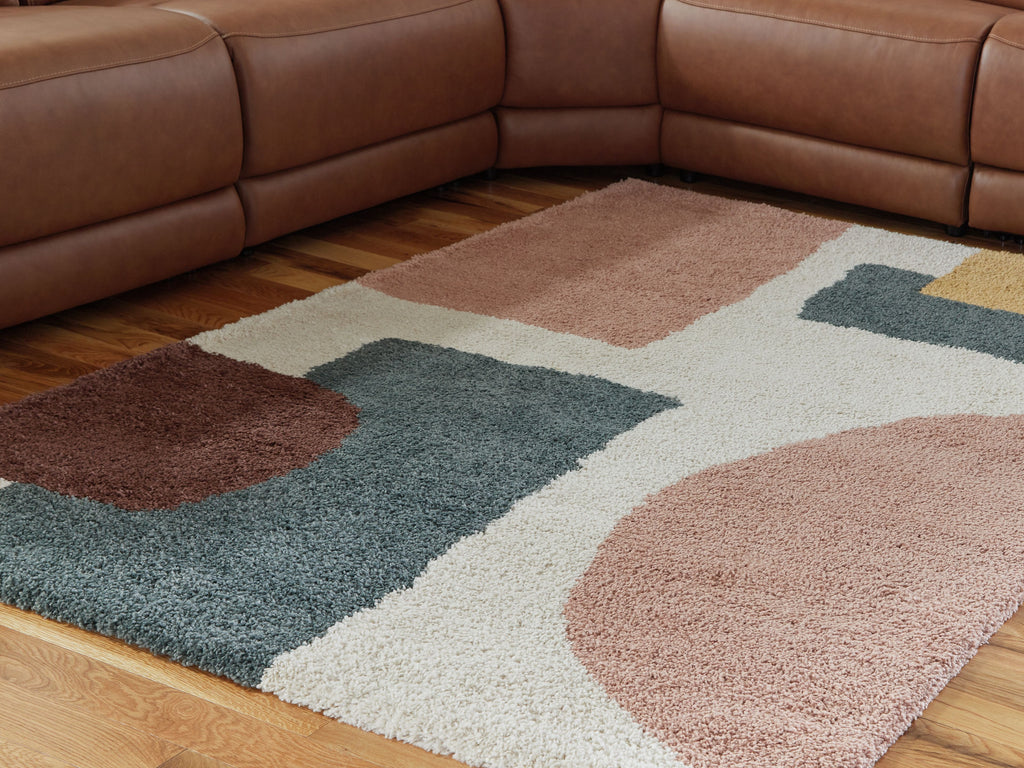 Geometric area rug in pink, tan, teal, and white with bold curves