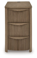 Light brown chair side end table with vertical slat panels and three drawer compartments