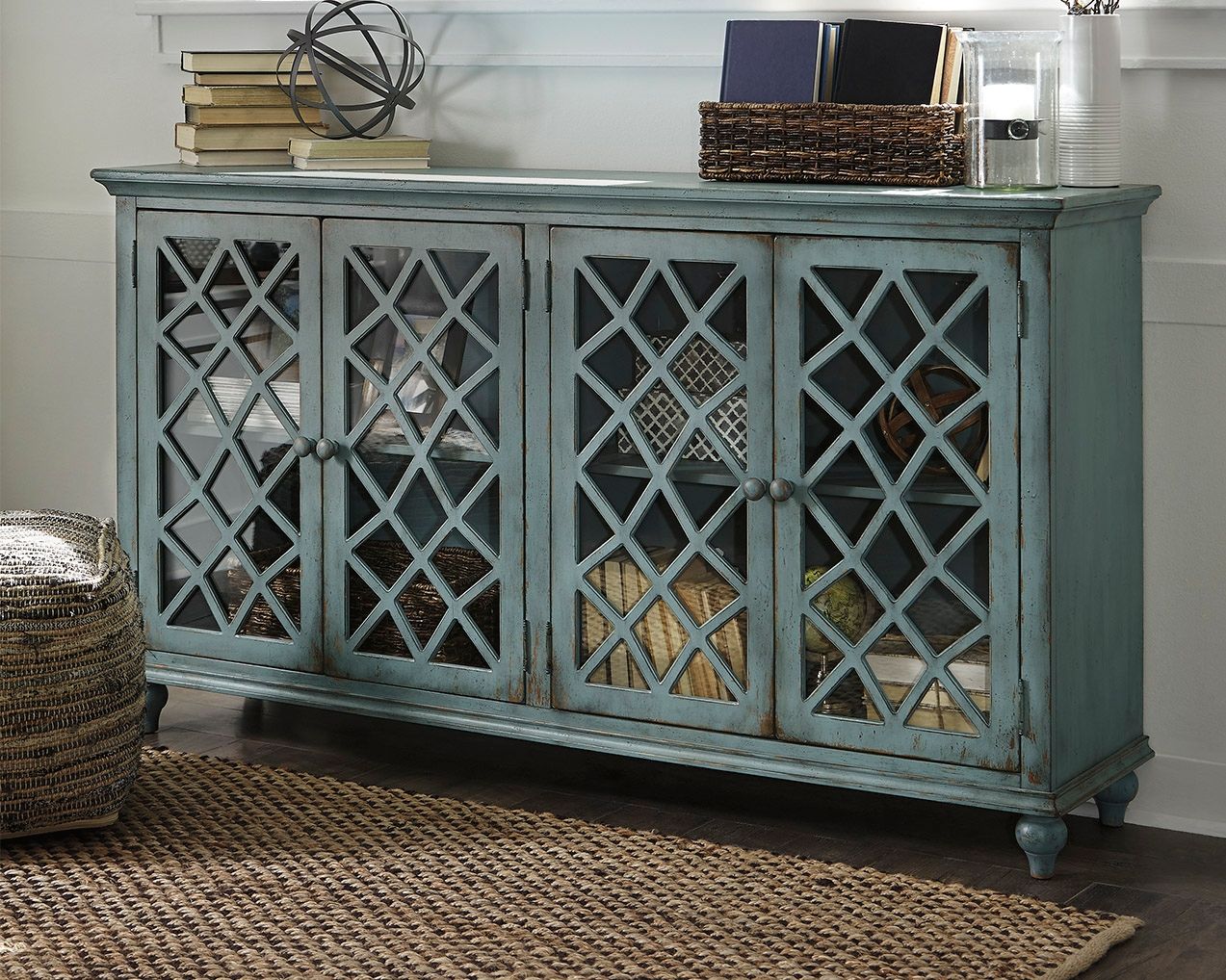 Teal accent cabinet with four paneled lattice doors and decorative knob pulls